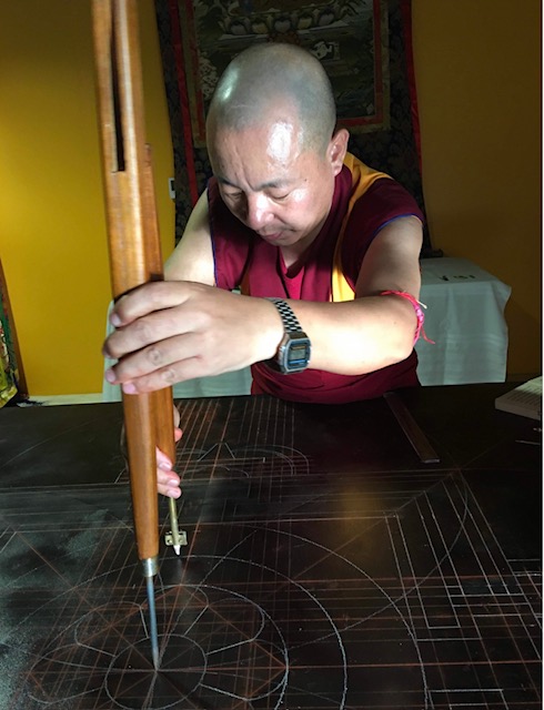 Rinpoche drawing the geometry of a sand mandala